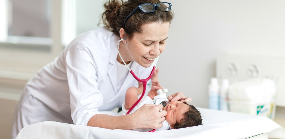Pädiaterin untersucht Neugeborenes im Spital Zollikerberg