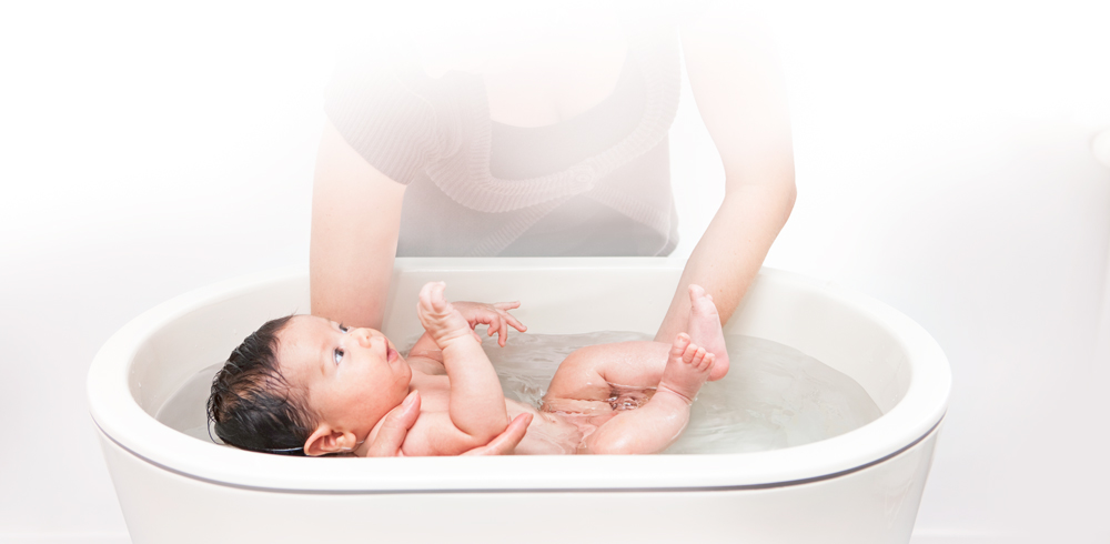 Baby geniesst erstes Bad im Gebärsaal, gemeinsamer Start von Mutter und Kind